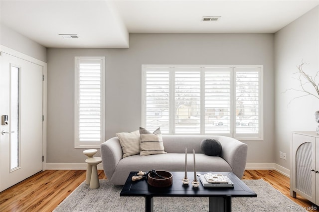 living room featuring plenty of natural light and light hardwood / wood-style flooring