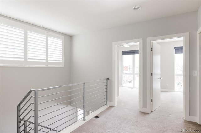 hallway featuring light colored carpet