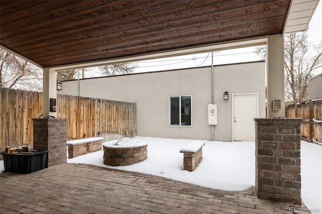 snow covered patio with a fire pit