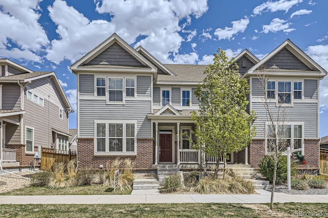 townhome / multi-family property featuring brick siding and covered porch