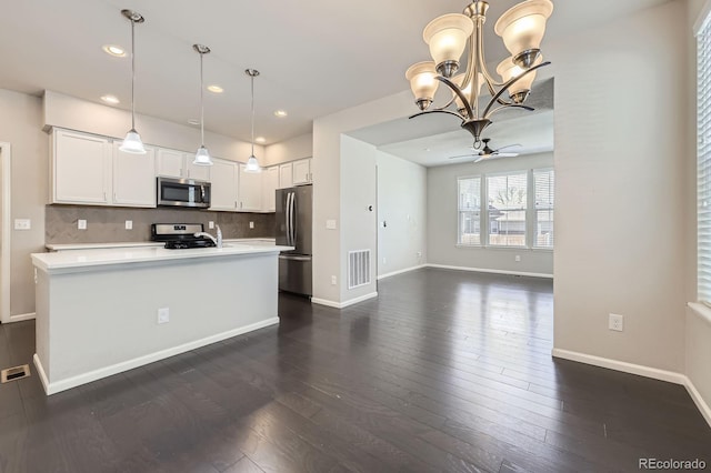 kitchen with tasteful backsplash, appliances with stainless steel finishes, light countertops, white cabinetry, and visible vents