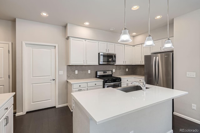 kitchen with white cabinets, stainless steel appliances, baseboards, and a sink