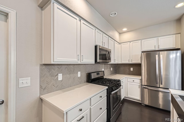 kitchen featuring light countertops, appliances with stainless steel finishes, decorative backsplash, and white cabinets
