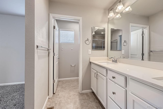 full bath with baseboards, a sink, and double vanity