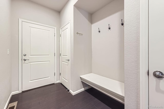mudroom with visible vents, baseboards, and dark wood-style floors