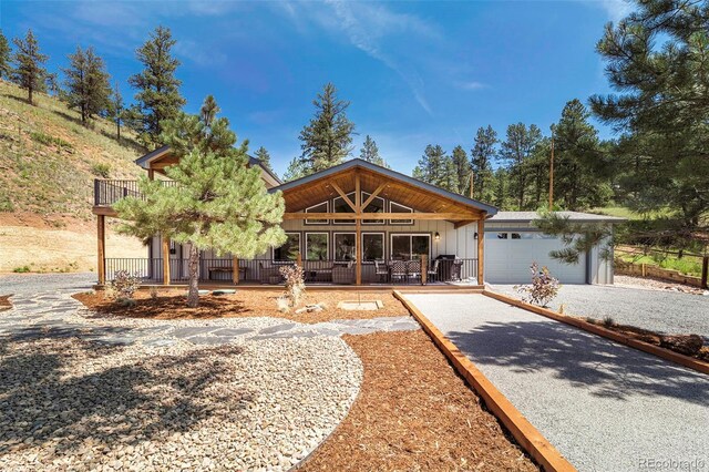 2230 S Platte River Rd, Sedalia, CO 80135 - view of front of property featuring a porch, an attached garage, board and batten siding, and gravel driveway