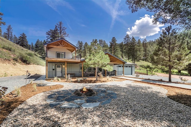 2230 S Platte River Rd, Sedalia, CO 80135 - view of front facade with an outdoor fire pit, a balcony, and covered porch