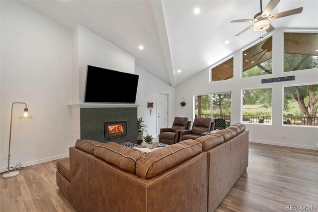 2230 S Platte River Rd, Sedalia, CO 80135 - living room featuring light wood-style floors, high vaulted ceiling, a glass covered fireplace, a ceiling fan, and baseboards