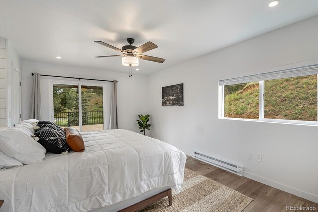 2230 S Platte River Rd, Sedalia, CO 80135 - bedroom with baseboard heating, access to exterior, recessed lighting, baseboards, and wood finished floors
