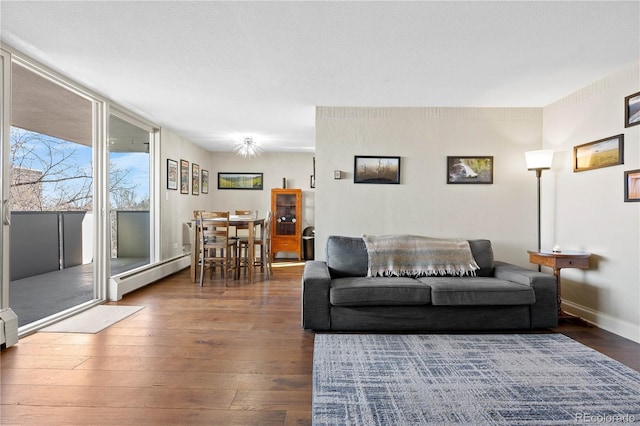 living room with hardwood / wood-style floors, a baseboard radiator, and baseboards