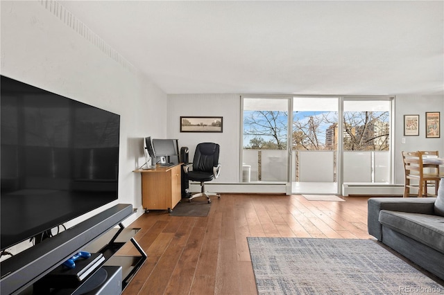 home office featuring a baseboard heating unit, hardwood / wood-style floors, and a wall of windows