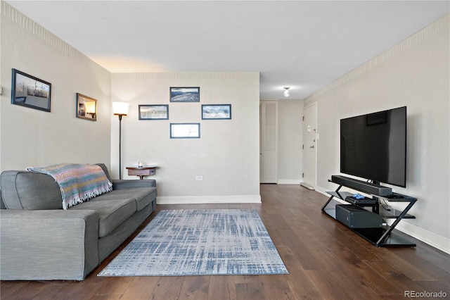 living area with baseboards and wood finished floors