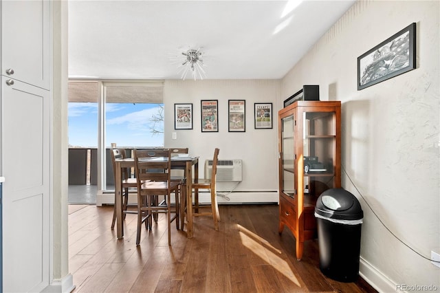 dining room featuring baseboards, baseboard heating, wood finished floors, and a wall mounted air conditioner