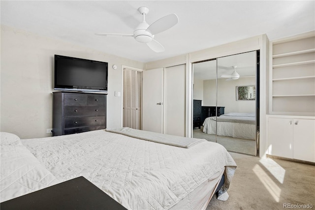 bedroom with multiple closets, carpet flooring, and ceiling fan