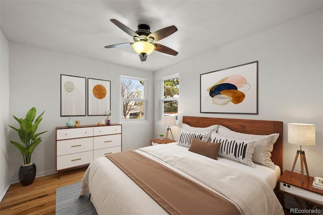 bedroom with light wood-style flooring, baseboards, and a ceiling fan