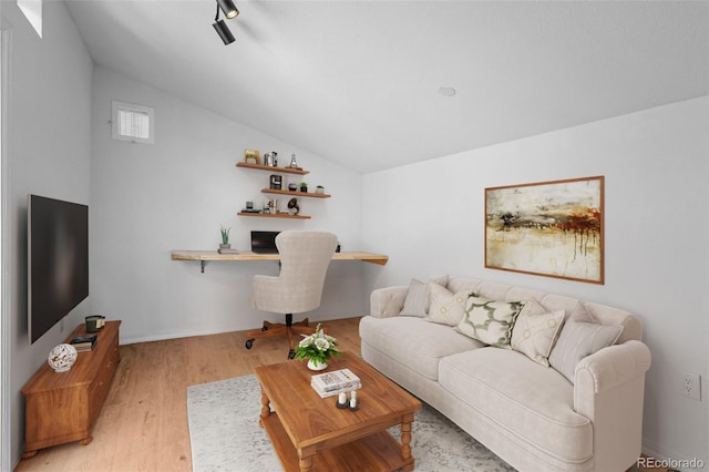 living area featuring light wood-style flooring, lofted ceiling, baseboards, and an office area