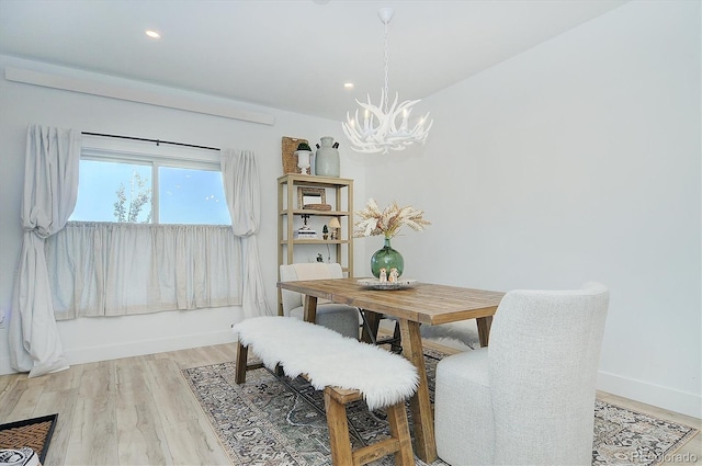 dining area with a notable chandelier and hardwood / wood-style floors