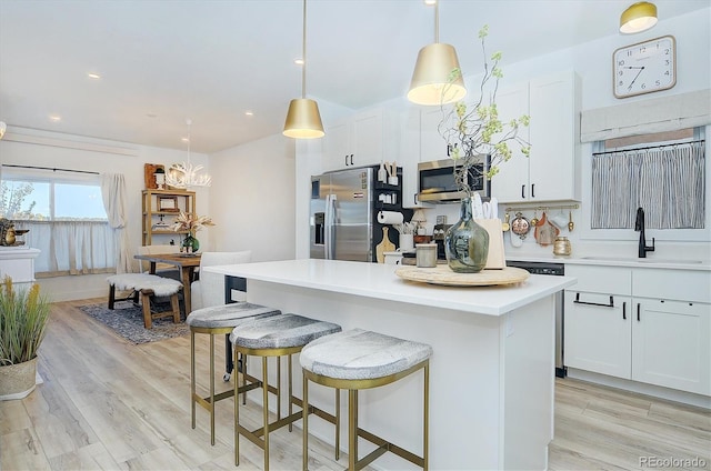 kitchen with sink, decorative light fixtures, white cabinets, and appliances with stainless steel finishes