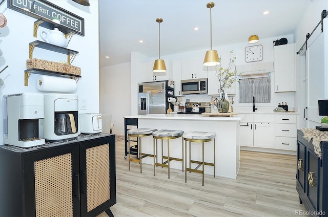 kitchen featuring decorative light fixtures, white cabinets, and appliances with stainless steel finishes