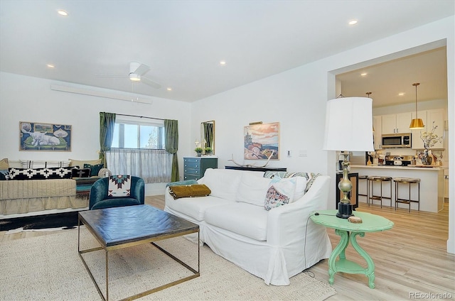 living room with ceiling fan and light wood-type flooring