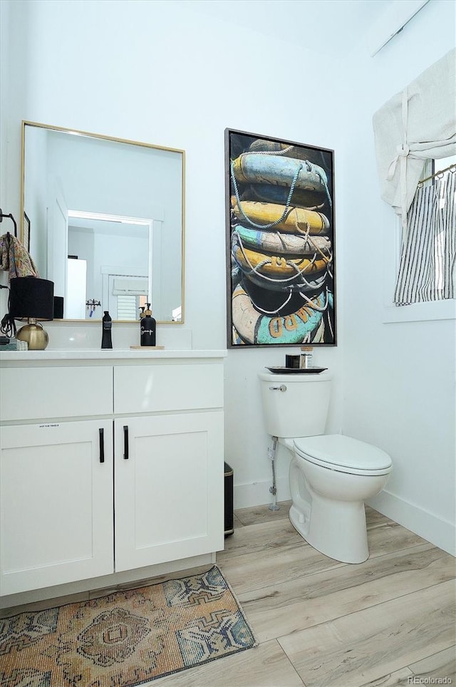 bathroom with hardwood / wood-style flooring, vanity, and toilet