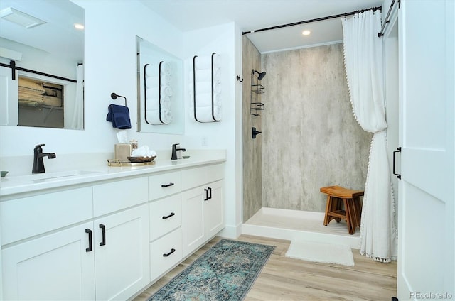 bathroom featuring a shower, hardwood / wood-style floors, and vanity