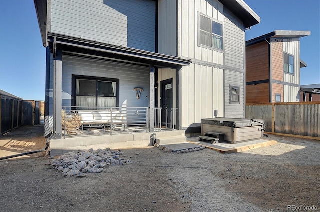 back of house with a hot tub