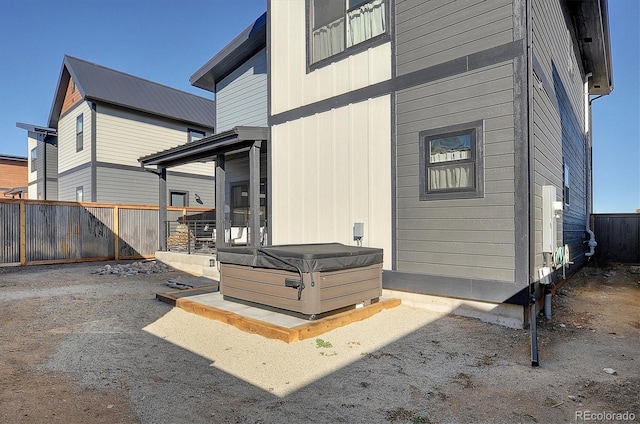 view of side of property with a hot tub