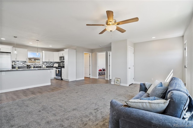 living room featuring ceiling fan and dark hardwood / wood-style flooring