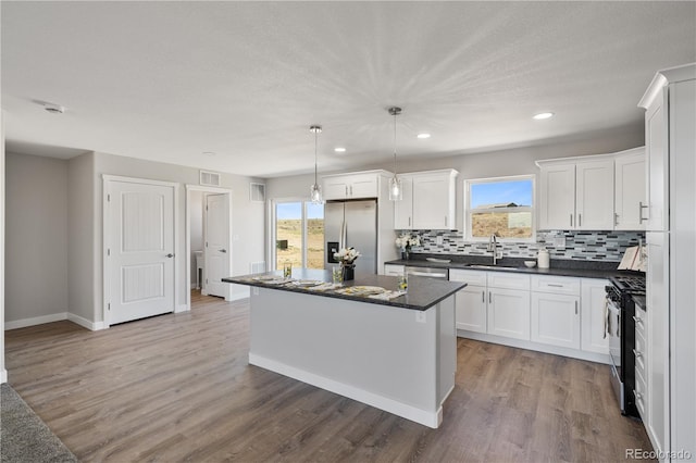 kitchen featuring appliances with stainless steel finishes, hardwood / wood-style floors, a wealth of natural light, and a kitchen island