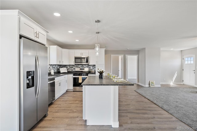 kitchen featuring white cabinets, appliances with stainless steel finishes, a center island, and light wood-type flooring