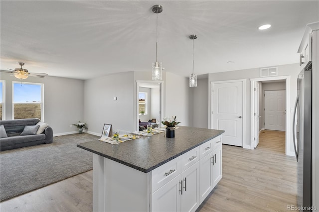 kitchen with hanging light fixtures, light hardwood / wood-style flooring, ceiling fan, and white cabinetry