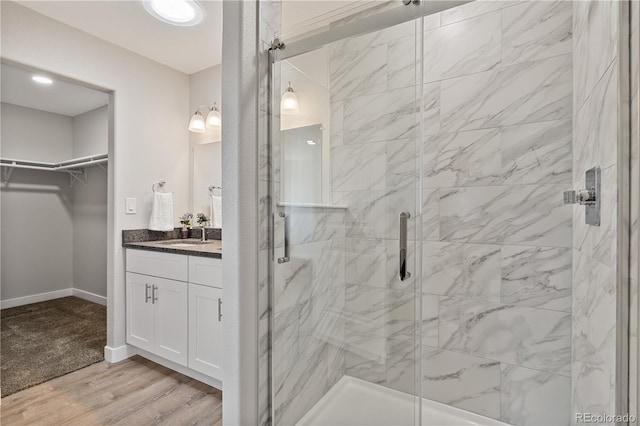 bathroom featuring an enclosed shower, wood-type flooring, and vanity