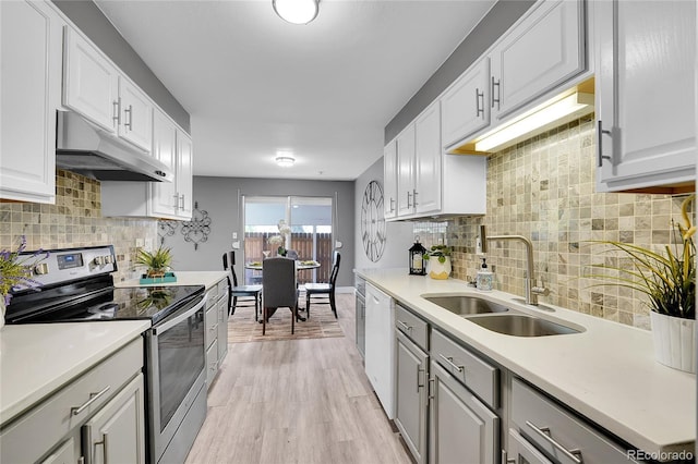 7902 Meade St Unit A10, Westminster, CO 80030 - kitchen featuring stainless steel electric stove, a sink, under cabinet range hood, light wood-style flooring, and light countertops