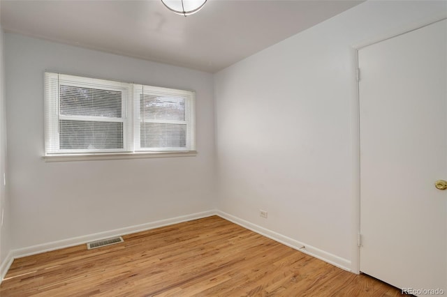 unfurnished room with light wood-type flooring, visible vents, and baseboards