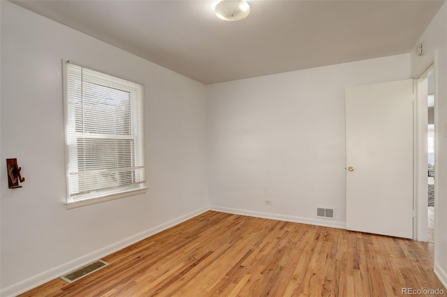 spare room with visible vents, light wood-style flooring, and baseboards