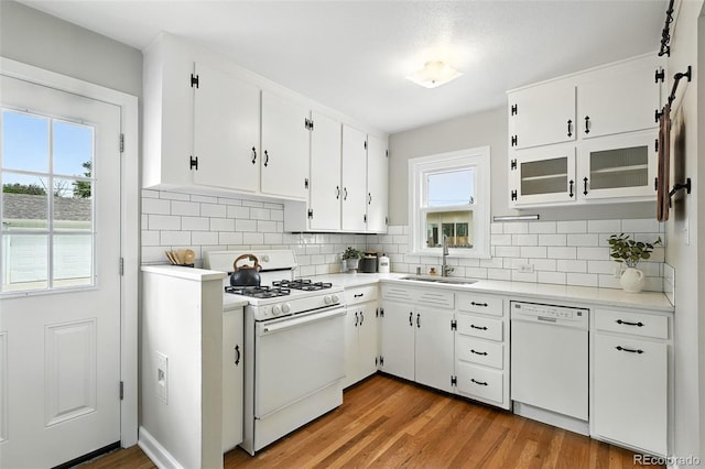2000 S King St, Denver, CO 80219 - kitchen with white appliances, light countertops, white cabinetry, light wood-type flooring, and tasteful backsplash