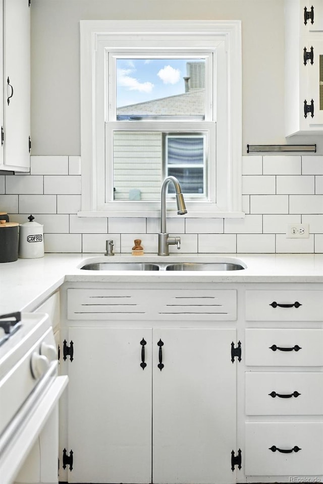 2000 S King St, Denver, CO 80219 - kitchen featuring white stove, tasteful backsplash, white cabinetry, and light countertops
