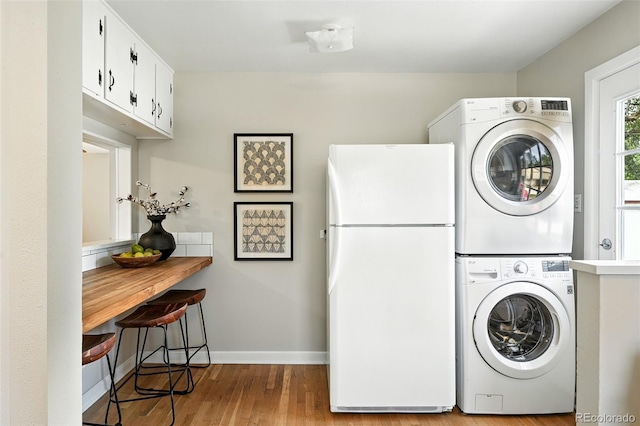 2000 S King St, Denver, CO 80219 - washroom featuring estacked washer and dryer and wood finished floors