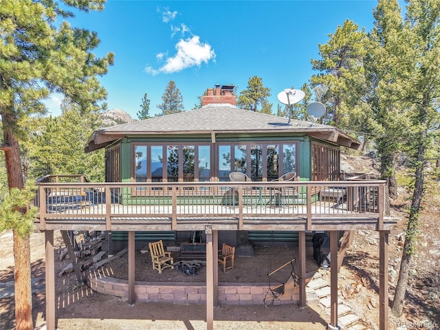 693 Rd C, Pine, CO 80470 - back of house with a deck, a chimney, and roof with shingles