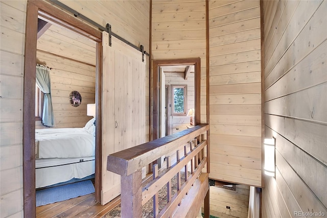 693 Rd C, Pine, CO 80470 - hallway featuring wood walls, a barn door, and wood finished floors