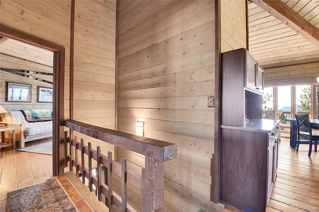 693 Rd C, Pine, CO 80470 - hallway with wooden walls, light wood-style flooring, an upstairs landing, and wood ceiling
