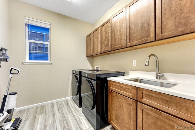 2775 Morningbird Ln, Castle Rock, CO 80109 - laundry area featuring cabinet space, separate washer and dryer, light wood finished floors, and baseboards