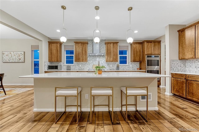 2775 Morningbird Ln, Castle Rock, CO 80109 - kitchen featuring appliances with stainless steel finishes, brown cabinets, light wood-style flooring, tasteful backsplash, and recessed lighting