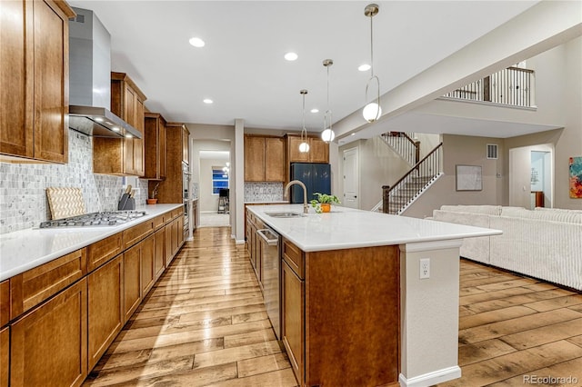 2775 Morningbird Ln, Castle Rock, CO 80109 - kitchen with wall chimney range hood, light wood finished floors, stainless steel appliances, a sink, and recessed lighting