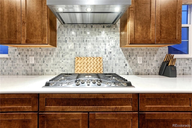 2775 Morningbird Ln, Castle Rock, CO 80109 - kitchen with extractor fan, stainless steel gas cooktop, light countertops, and tasteful backsplash