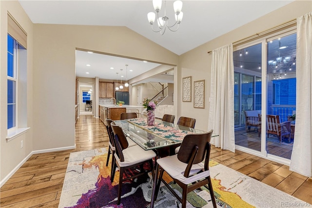 2775 Morningbird Ln, Castle Rock, CO 80109 - dining room featuring a chandelier, light wood-type flooring, stairs, vaulted ceiling, and baseboards