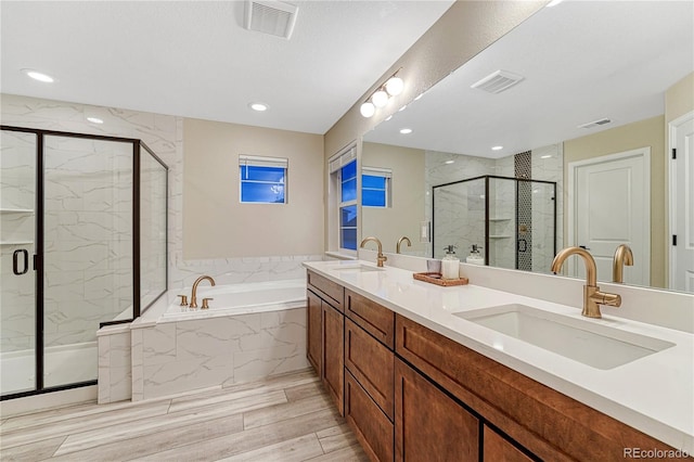 2775 Morningbird Ln, Castle Rock, CO 80109 - bathroom featuring a garden tub, a marble finish shower, double vanity, wood finished floors, and recessed lighting