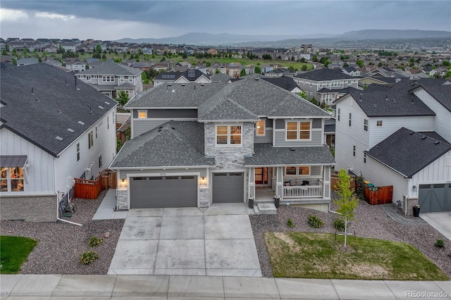 2775 Morningbird Ln, Castle Rock, CO 80109 - view of front of home featuring stone siding, covered porch, a residential view, concrete driveway, and roof with shingles