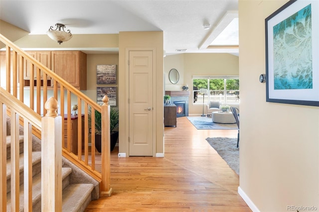 9168 W 50th Ln Unit 1, Arvada, CO 80002 - stairs with a warm lit fireplace and wood finished floors